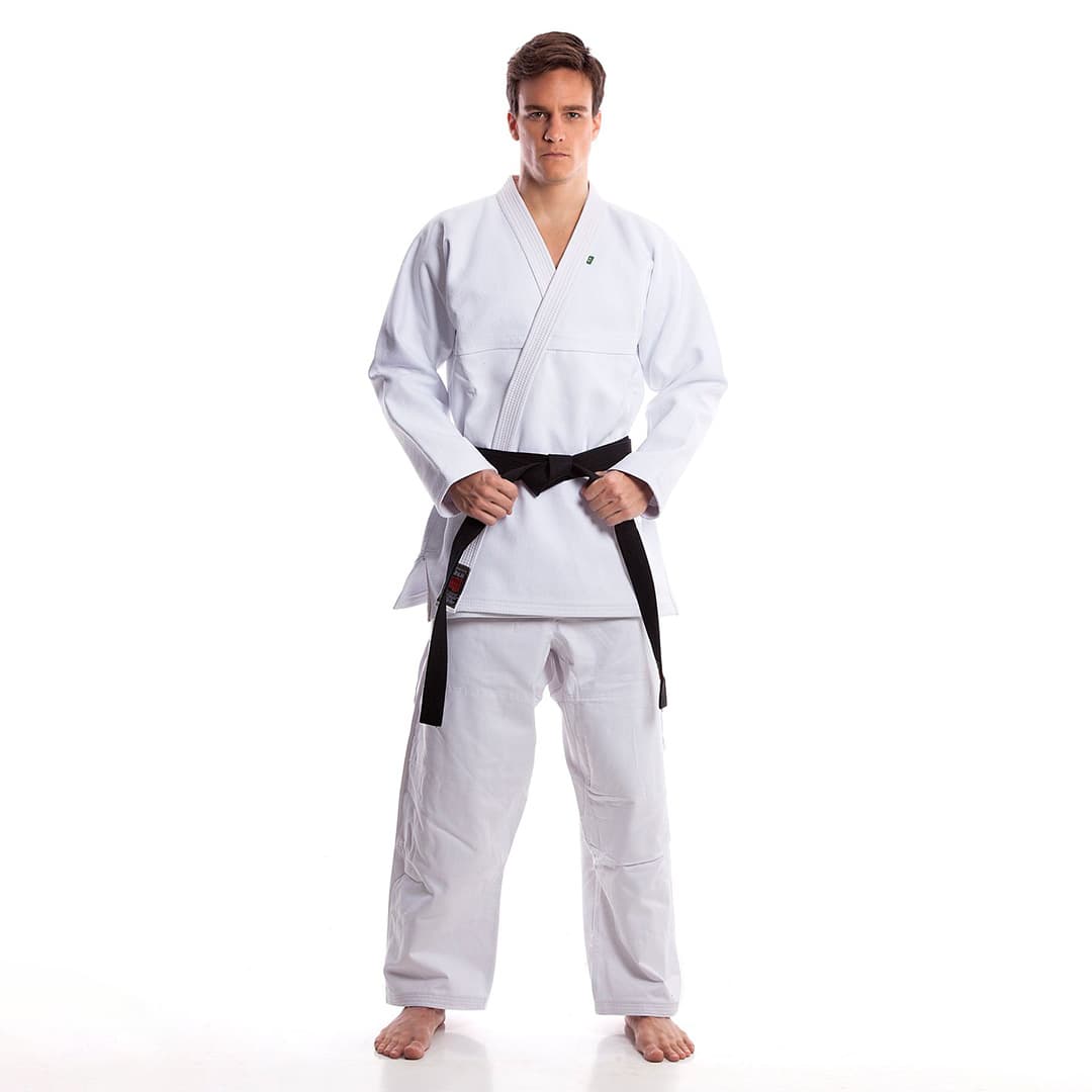 Martial arts team wearing custom logo jiu jitsu uniforms with embroidered patches and branding, standing proudly together.