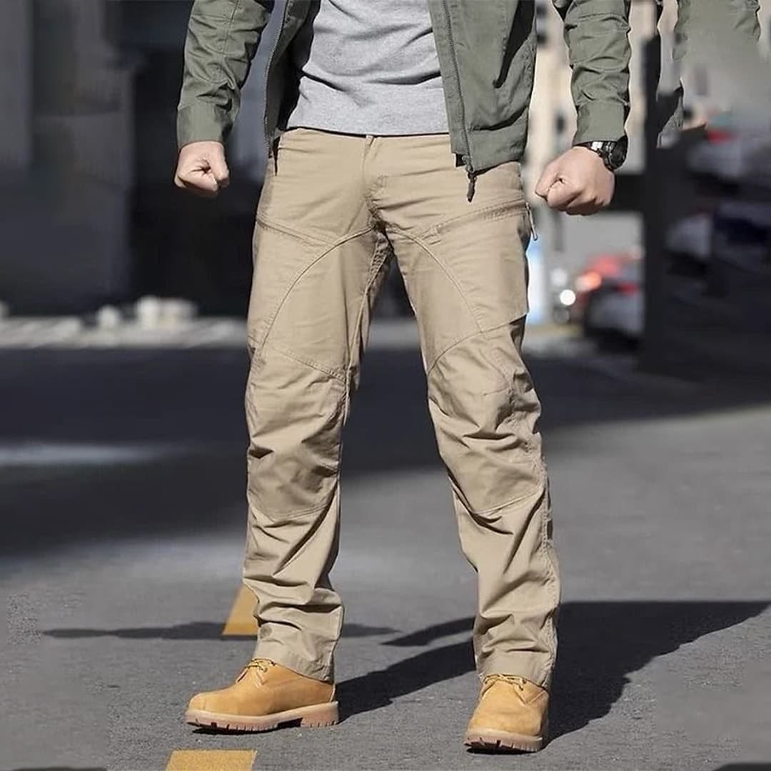Custom tactical pants showing reinforced stitching and durable material in action walking through rough terrain.